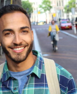 Handsome ethnic young male smiling outdoors. Handsome ethnic young male smiling outdoors.